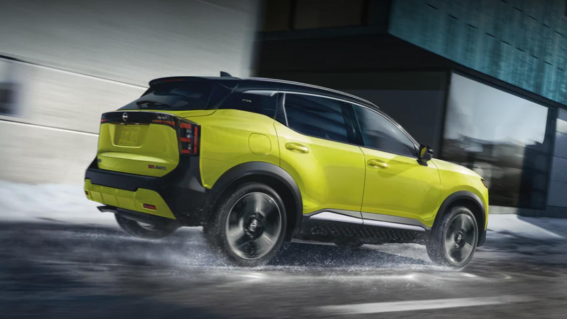 Vue 3/4 arrière du Nissan Kicks 2025 roulant sur une route glissante.